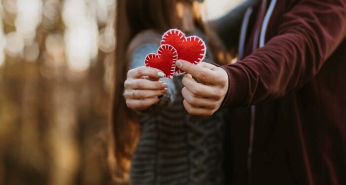 Photo of couple holding cutouts of hearts illustrates blog: "Reasons to Love Your Air Conditioning"