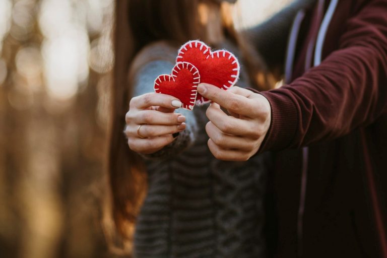 Photo of couple holding cutouts of hearts illustrates blog: "Reasons to Love Your Air Conditioning"