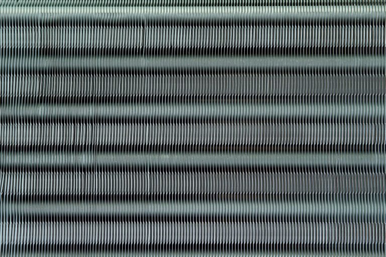 Photo of coil fins illustrates blog: "Why Is It Important to Fix Bent Coil Fins? Bent condenser coil fins may seem like small potatoes compared to other AC problems. However, while it’s true that this is a relatively simple task, that doesn’t mean that you should overlook it. Keep reading to learn more. Why Is It Important to Fix Bent Coil Fins? As you may have noticed, it’s not uncommon for the fins on your condenser coil to get bent over time. This is more than a cosmetic issue, as bent fins can impact the performance of your HVAC unit. Coil fins are really thin, so they can bend at the slightest contact, like hail, sleet, or pressure washing for example. Needless to say, you can also bend your coil fins while cleaning your coils or changing a filter. Coil fins play an important role in the heat transfer process that keeps your home cool. Bent coil fins increase heat retention, hindering the efficiency of your unit How To Fix Bent Condenser Coil Fins Straightening bent condenser coil fins is relatively easy but you should consider doing it yourself only if you feel 100% confident performing the tasks outlined below. If you don’t feel comfortable carrying out these steps, or just don’t have the time, don’t worry — you can always contact our experts at Zero Heating AC and Refrigeration, and they’ll take care of it. The first thing to do is to have the right tool, so make sure to purchase a coil fin comb. They usually come with several interchangeable heads, so you don’t have to worry about buying a specific type of comb. Turn off the power to your air conditioner Remove the panel and grille to expose the fins Remove screws and lift off the fan and grille Take off the plate to the evaporator coil Use the appropriate fin comb head and start straightening from the bottom I Zero Heating AC and Refrigeration: the Best In San Antonio, TX Whether you need to repair or replace your AC unit, Zero Heating AC and refrigeration and Refrigeration is your best option in San Antonio, Texas. Contact us today using our website, by telephone (210-900-0824), or through our social media accounts on Facebook and Twitter and to schedule a tune-up or to get a free estimate. We also offer financing plans for your convenience."