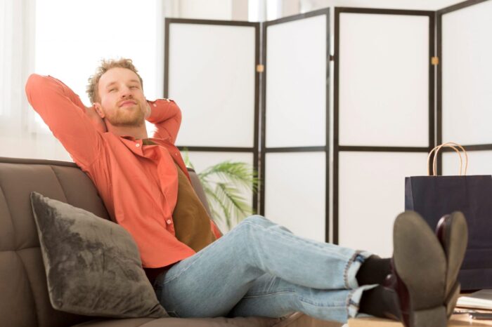 Man relaxing at home illustrates blog "Air Conditioning vs Fan: Which One Is Best?"