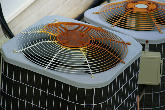 Technician inspecting old furnace to replace old heating system