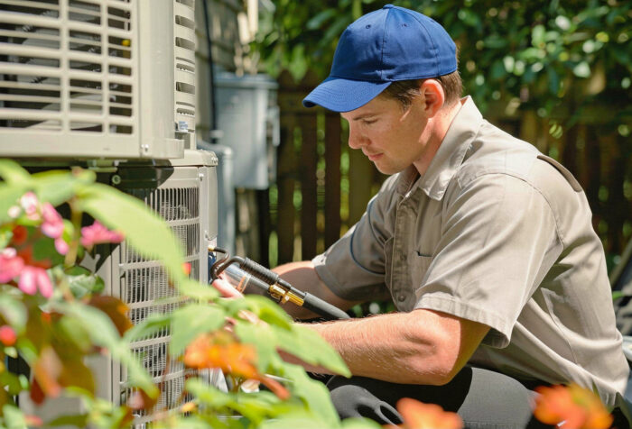 freepik__talk__62032 "homeowner performing spring AC maintenance on outdoor condenser unit"