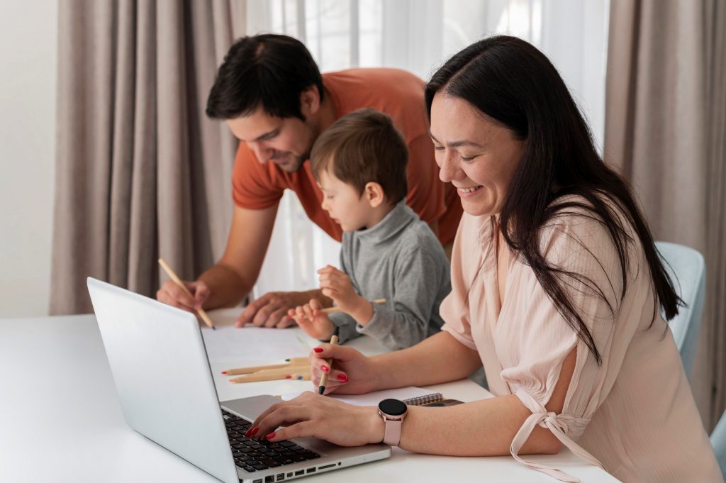Photo of family with laptop in living room illustrates blog: "How To Find the Most Efficient Temperature for Your AC"