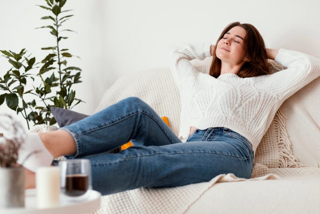 Girl relaxing on couch illustrates blog "5 Tips to Extend the Life of Your AC"