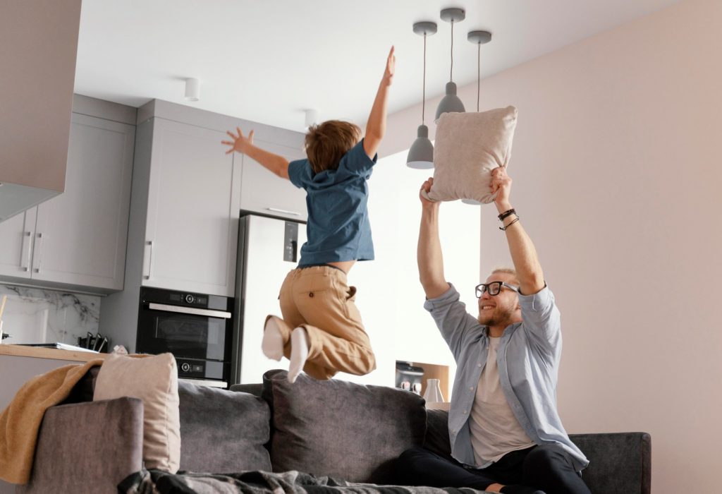 Adult and child playing in living room illustrate blog "5 Ways To Help Your AC on Hot Days"