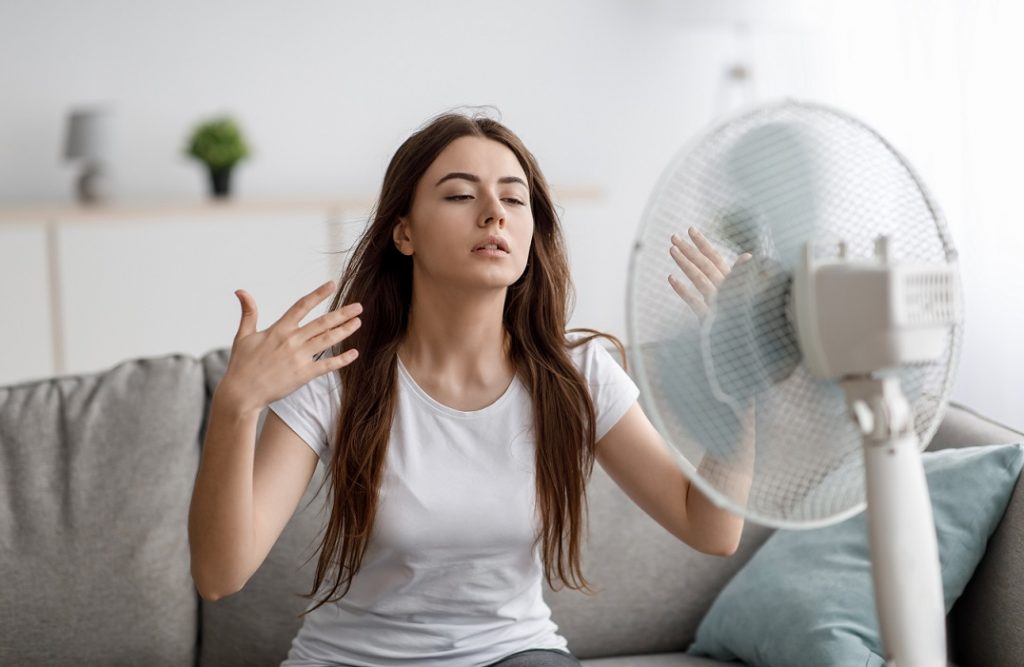 Woman fanning herself illustrates blog "My AC Can't Keep My House Cool. What To Do?"
