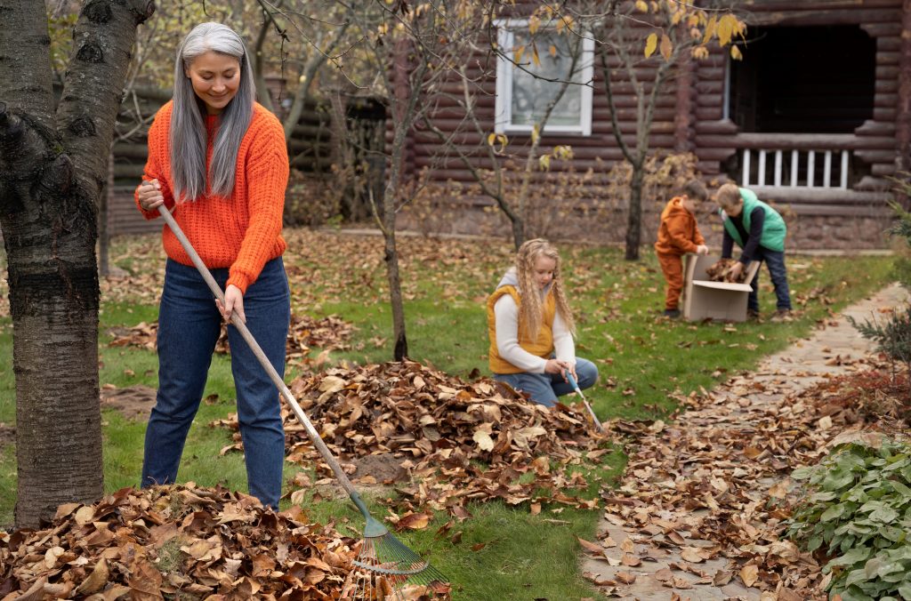 Woman and kids raking leaves illustrate blog "Reasons Why You Should Clean the Are Around Your AC Outside Unit"