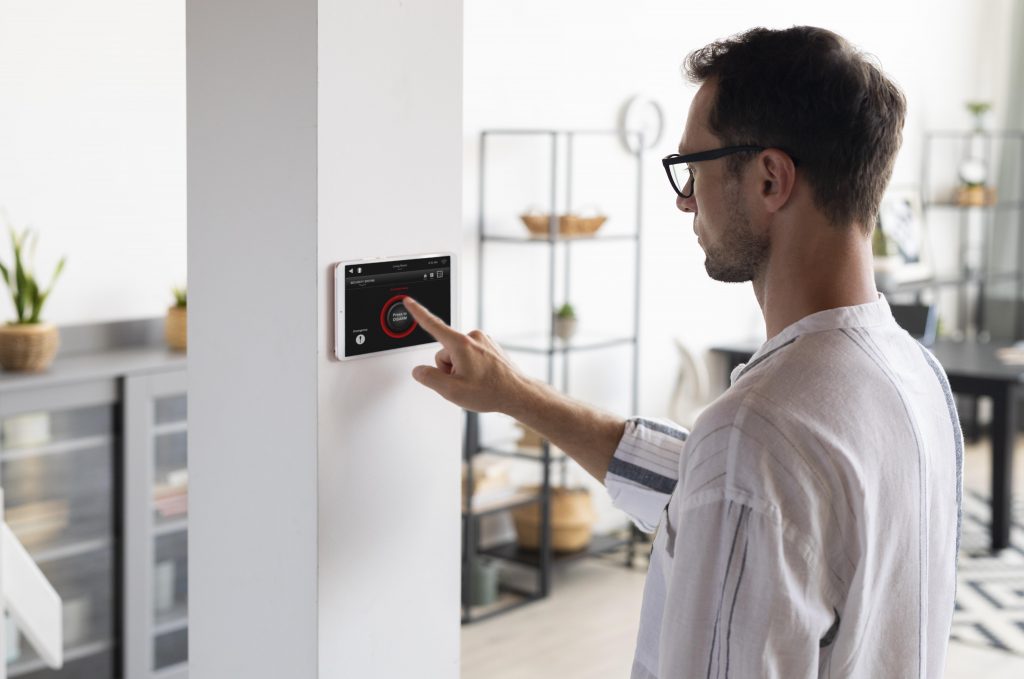 Man using digital thermostat illustrates blog "Why Is My Thermostat Not Getting Power?"