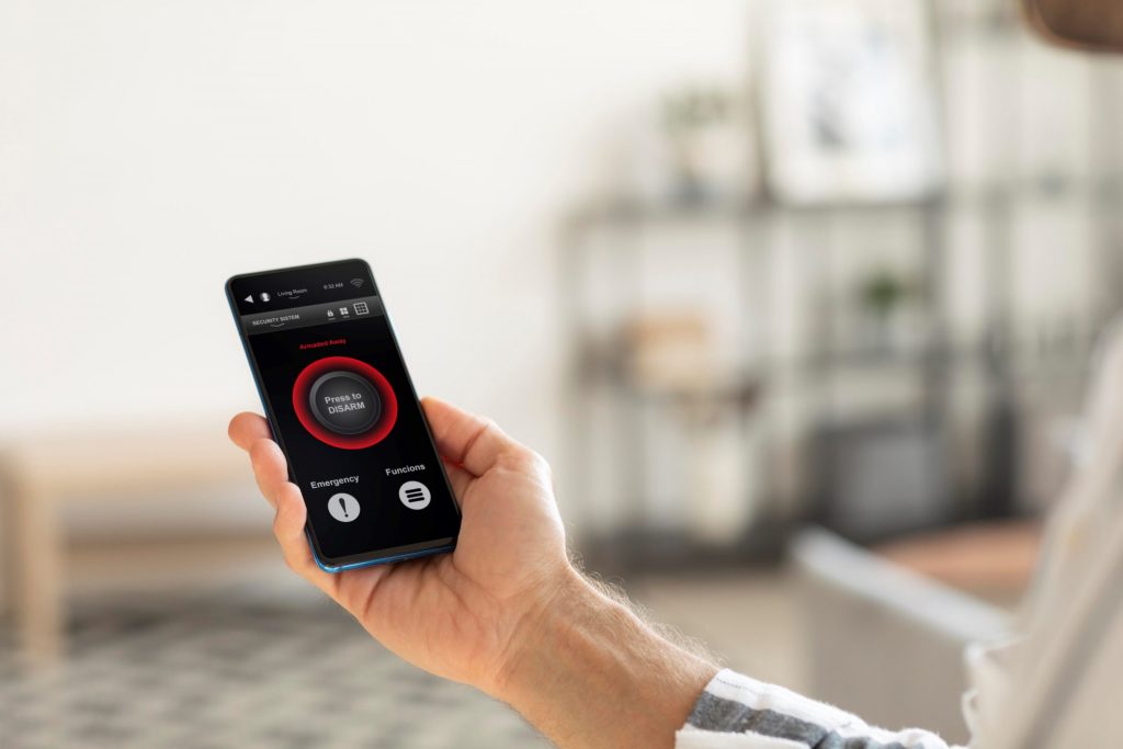 Closeup of person holding smartphone with smart thermostat app